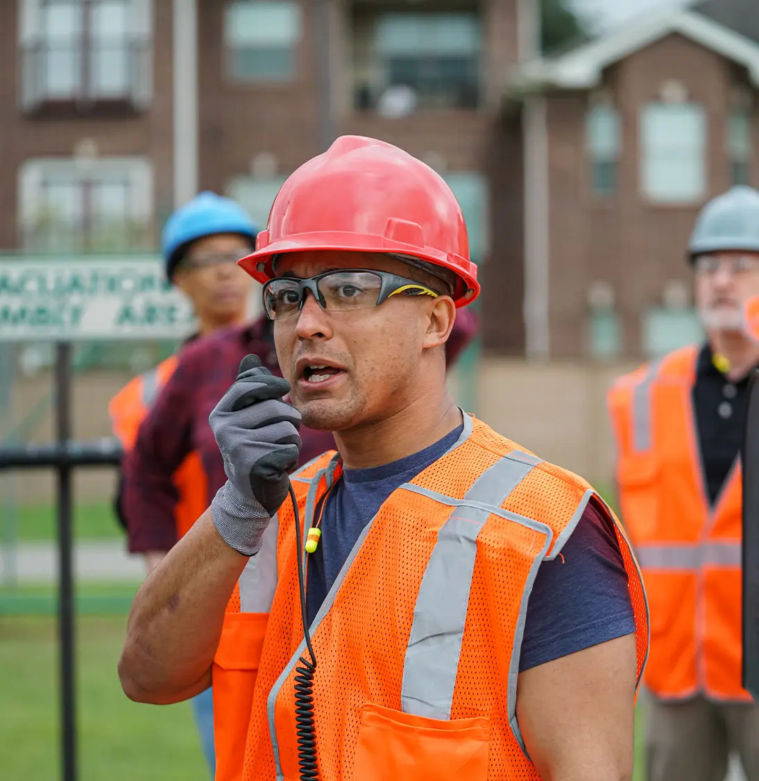 Worker in high vis speaking into handheld radio